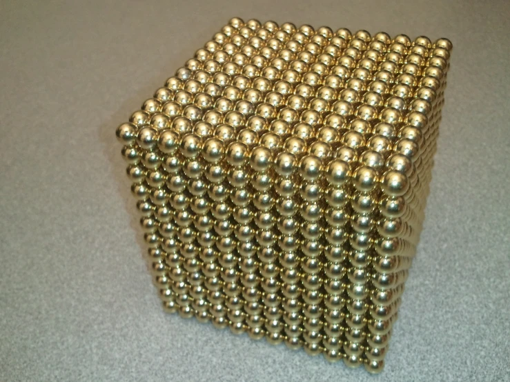 a gold cube is stacked up with balls