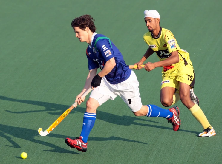 two men play a game of lacrosse on the field