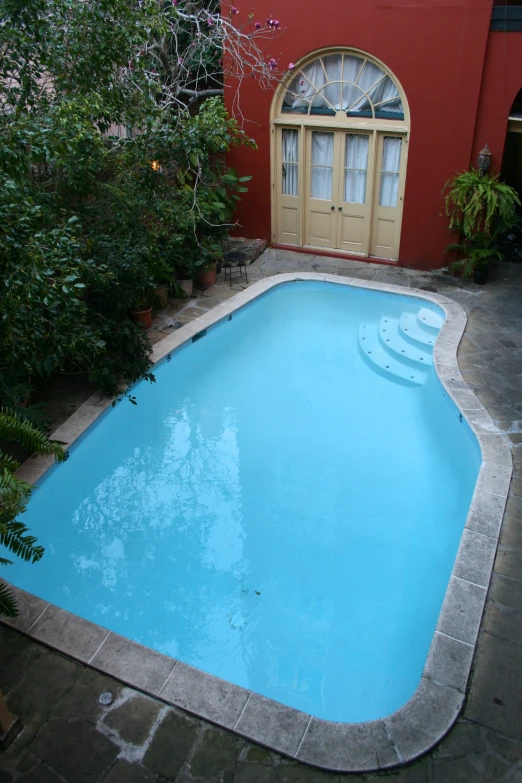 a red house with a large swimming pool