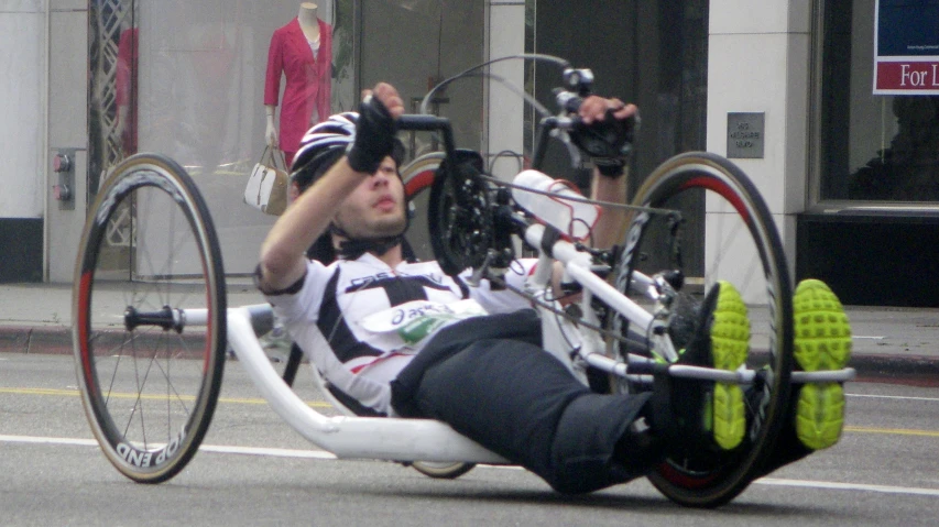 a woman laying on top of a bicycle down the street