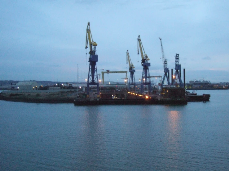 a harbor with lots of cranes near the ocean