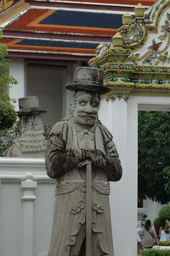 a statue of an old gentleman standing next to a building