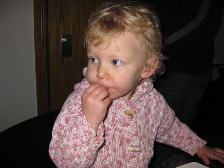 an adorable little blonde girl sitting at a table