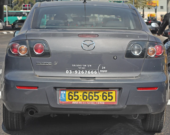 the back end of a car is parked on the side of the road