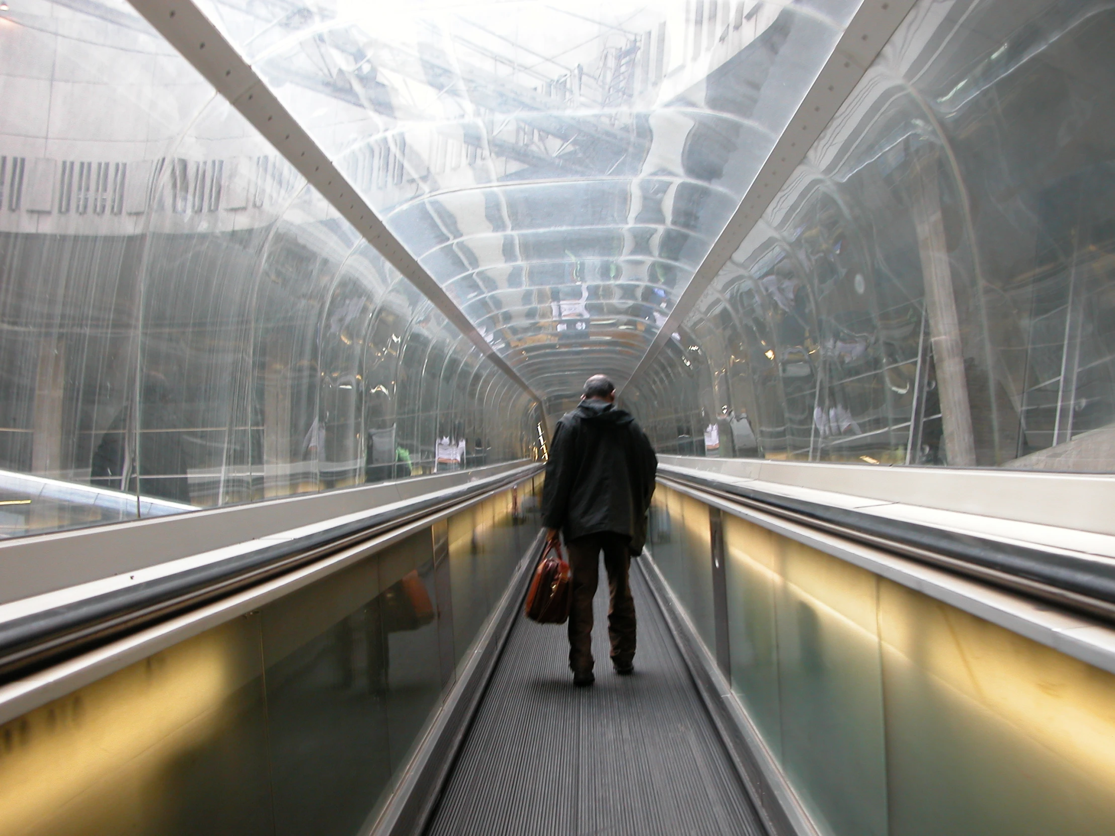 a man walking along a train track with luggage