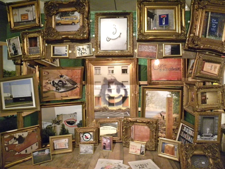 a wall with many framed pos and pictures