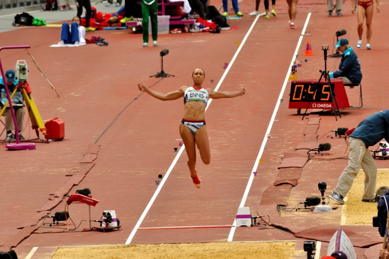 a female athlete in mid - air after performing a long jump