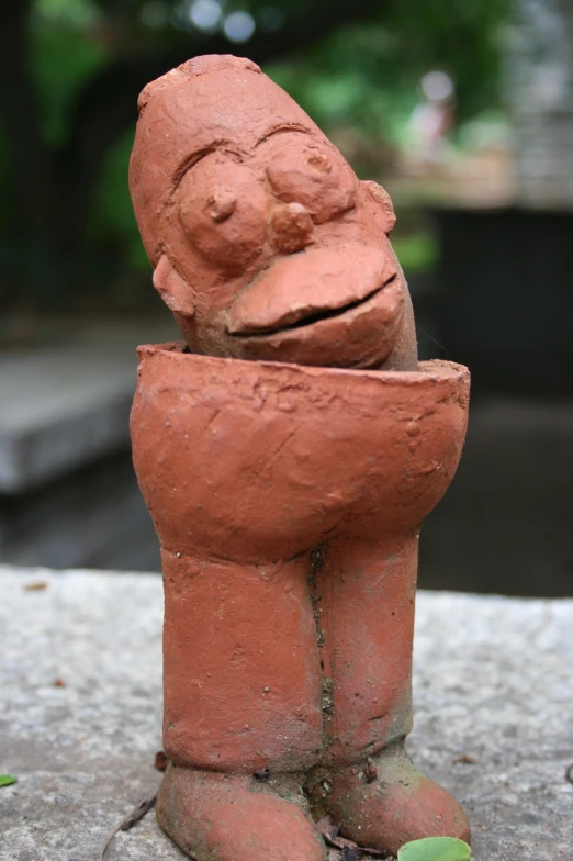 a clay statue of a small creature with its back turned