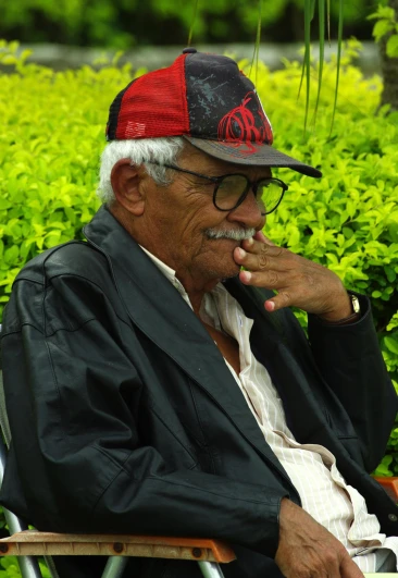 an old man sitting on a chair while smoking