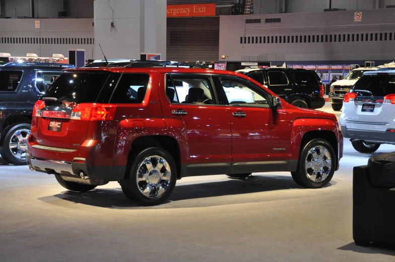 a red chevrolet suv is displayed in a showroom