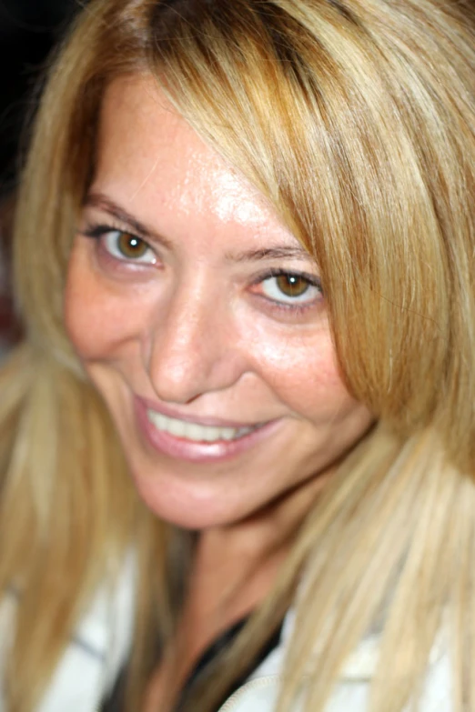 woman smiling at camera while holding food item