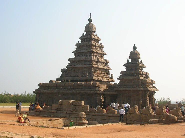 a group of people standing around a stone structure