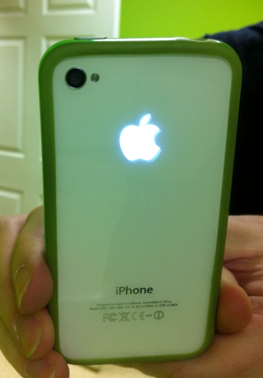 someone is holding up their new green iphone