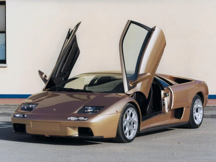 a brown and white sport car with it's doors open