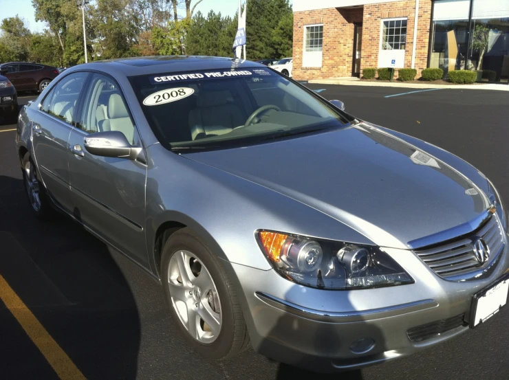 the gray toyota car is parked in front of the business