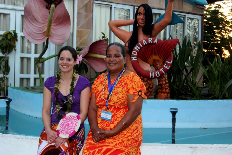 three women are standing outside by the pool