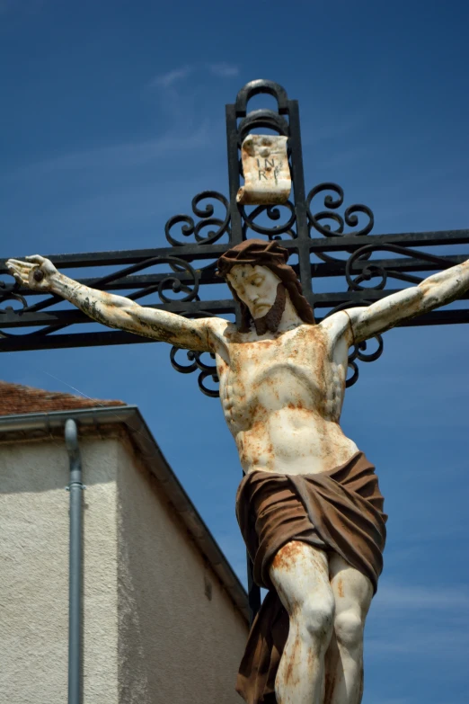 an antique statue of jesus nailed to a cross