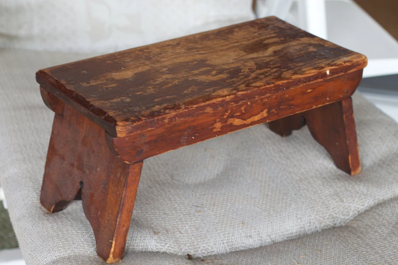 an old wooden step stool on a piece of linen