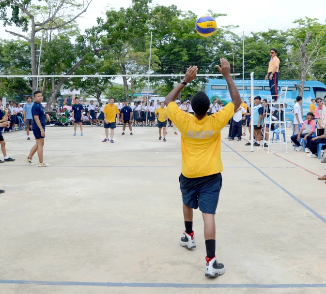 a group of people playing beach volleyball on a sandy court