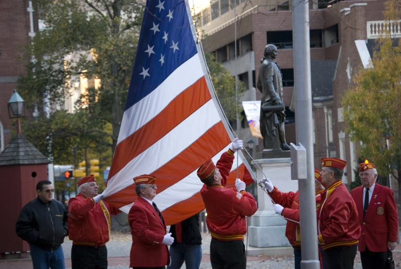 some men standing around holding a flag