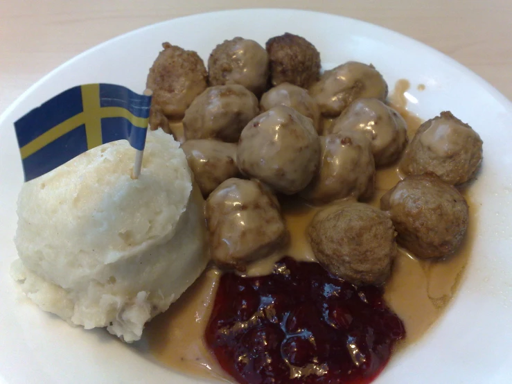 a plate full of meatballs, mashed potatoes and jelly