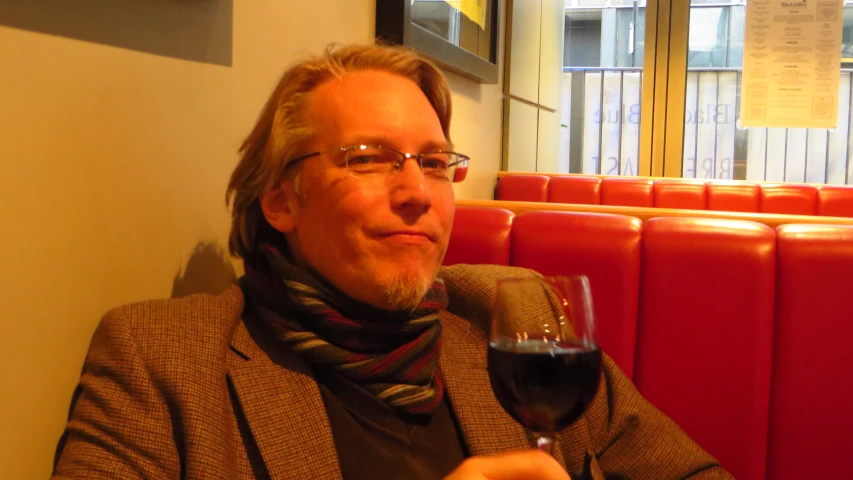 a man sitting next to a wine glass