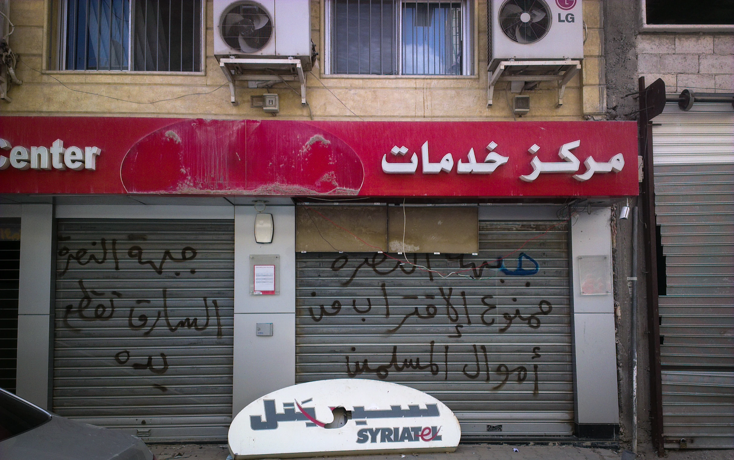 a large white sign and door with graffiti on it