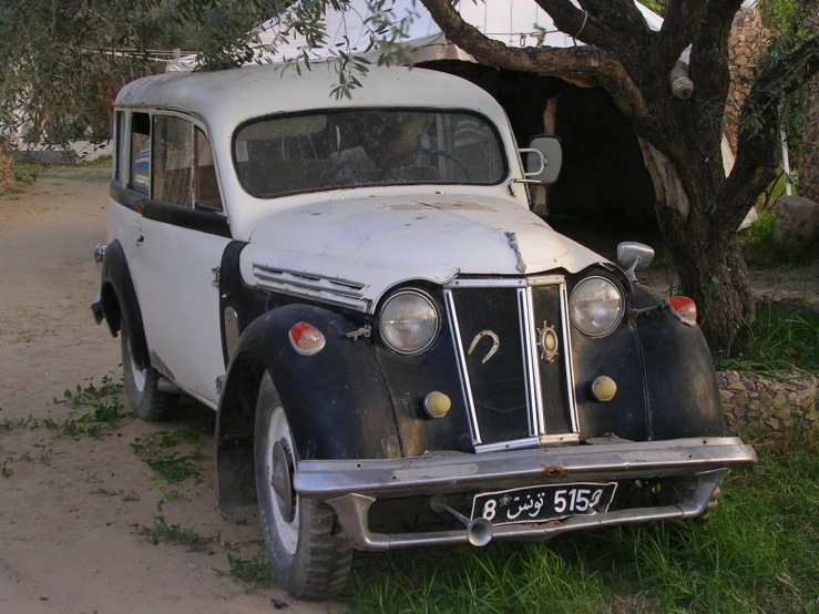 a vintage white truck parked in front of a tree