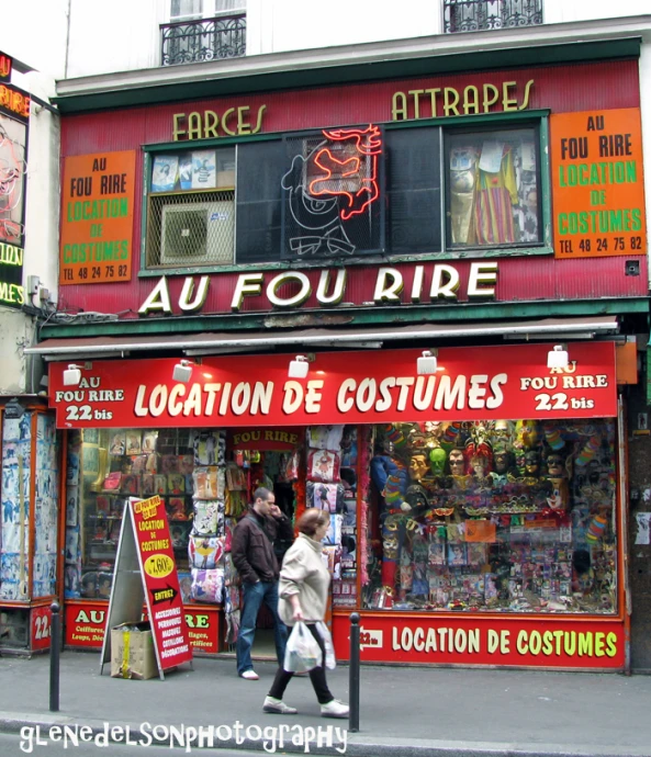 people are walking past an auto - soure shop on the street