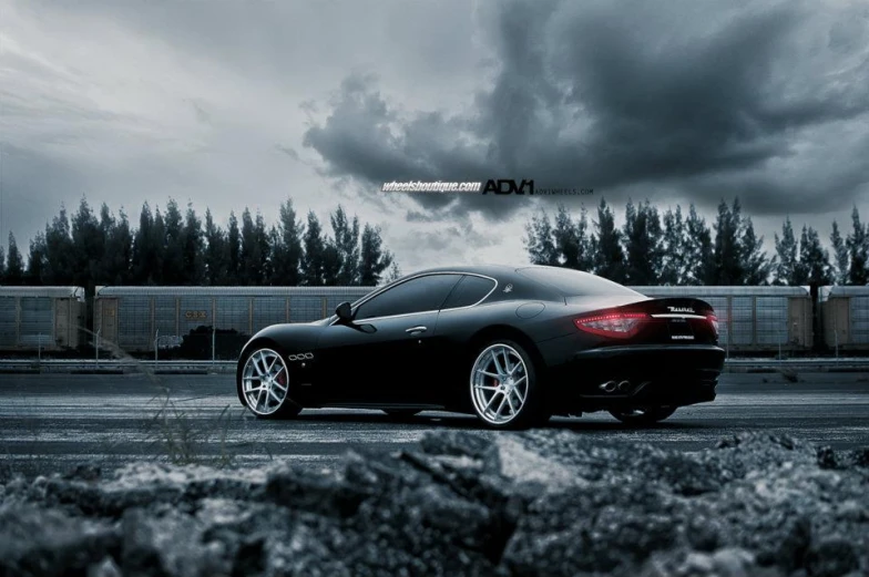 a black sports car parked under an ominous sky