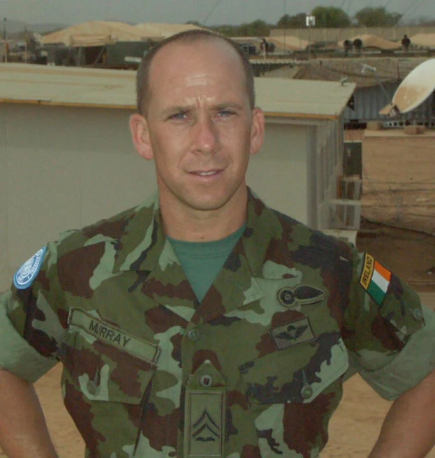 a soldier standing in front of tents with flags