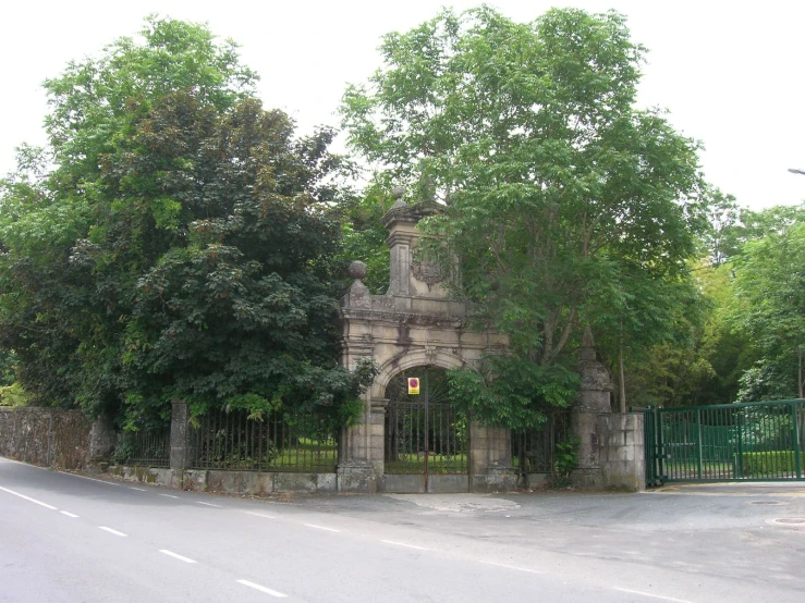 old building that has been abandoned and fenced off with trees
