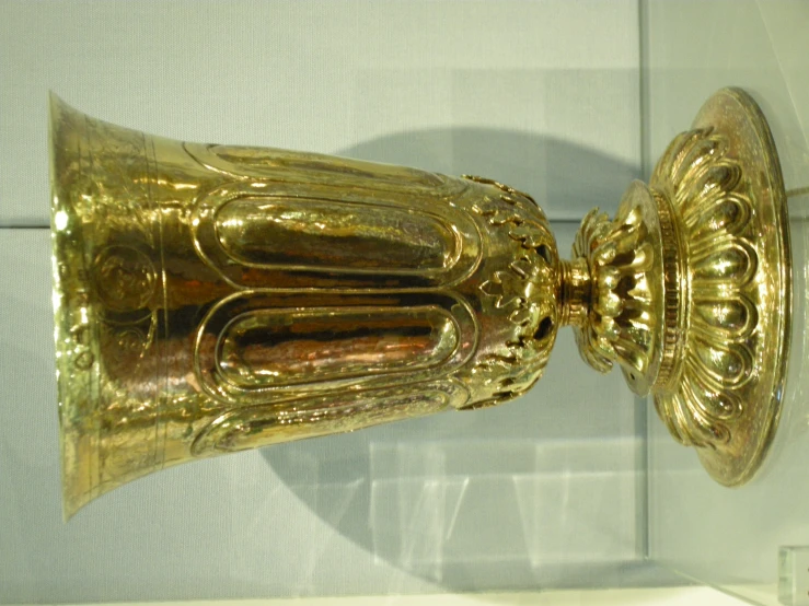 an elaborate looking gold trophy on display in a glass case