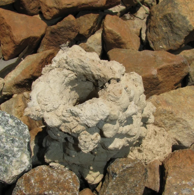 a rock wall of different rocks and concrete