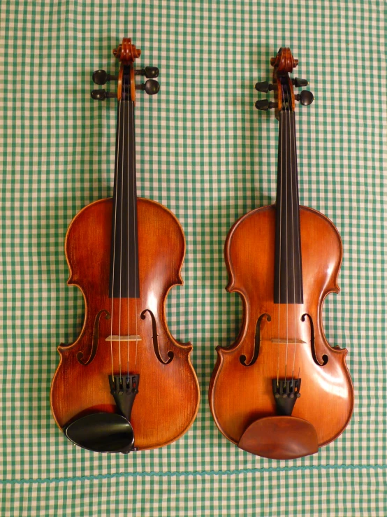 two violin's that are sitting on top of each other