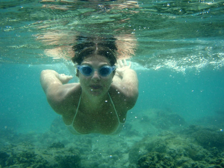 man underwater in the ocean, wearing glasses