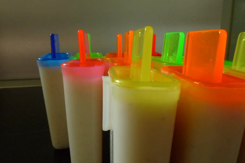 plastic tubes and orange, green, yellow, and blue top on table