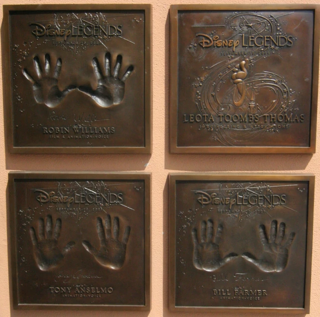 four bronze plaques on the wall that depict their names and handprints