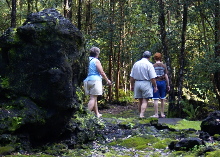 two men and a woman are walking down a pathway