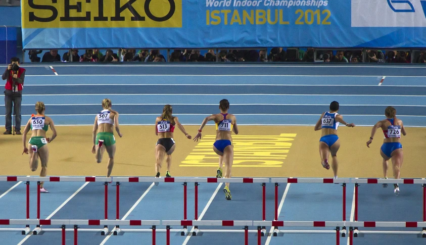 a group of young women running on top of a track