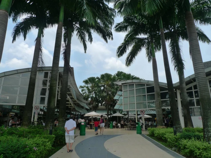 two people walking towards a building near a parking lot