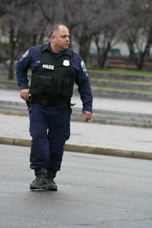 a police officer walking down a street near a bench