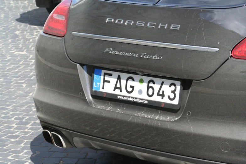 the back of a grey car with an license plate and license plate