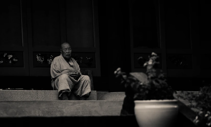 a man sitting down on steps near plants