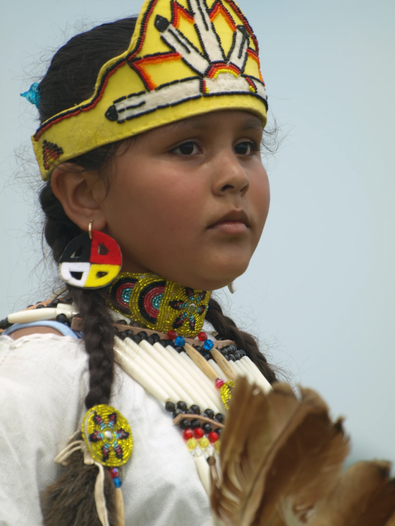 a little girl in native clothing and headgear