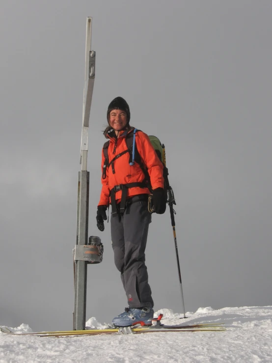 the person is standing next to a pole with a backpack on top