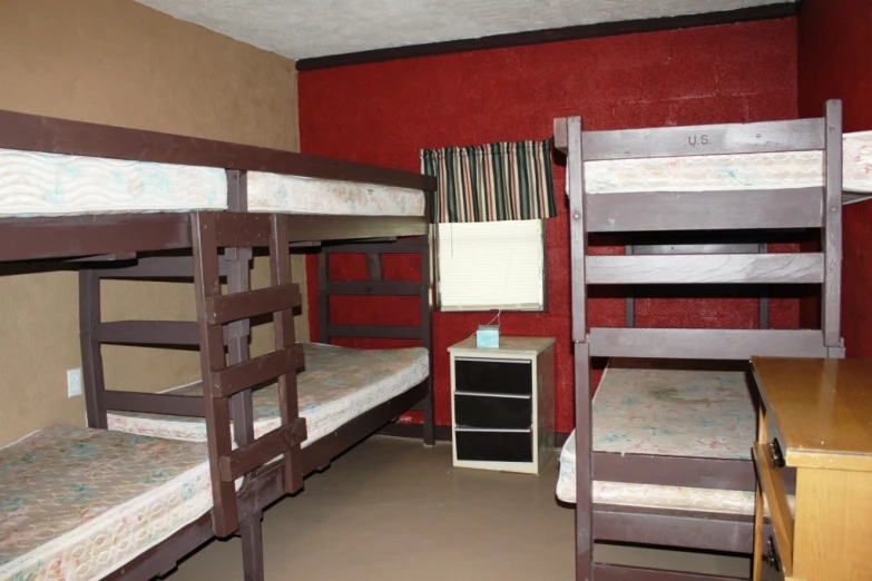 a room with three bunk beds and desk in it