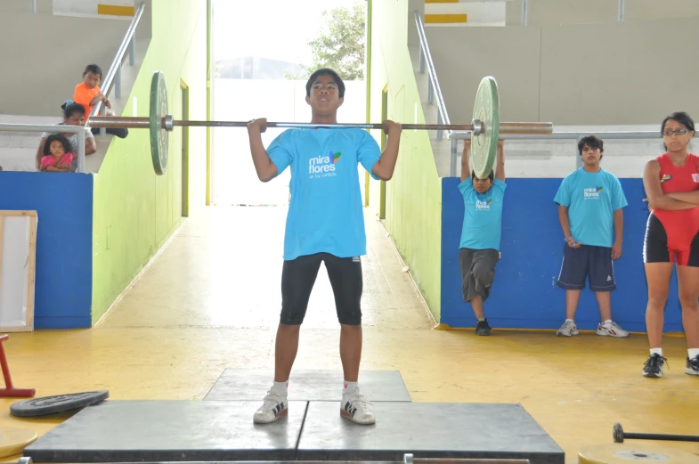 a man lifting heavy metal bars on a beam