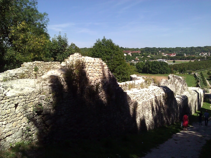 a group of people walking past some big stones