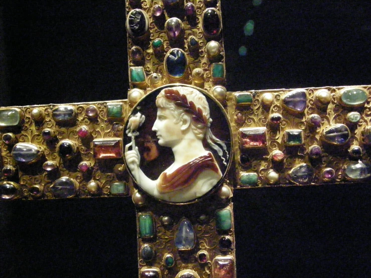 a gold and blue colored beaded cross has a religious figure